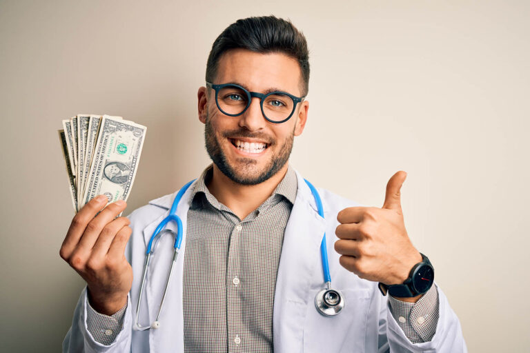 Young,Doctor,Man,Holding,A,Bunch,Of,One,Dollar,Banknotes